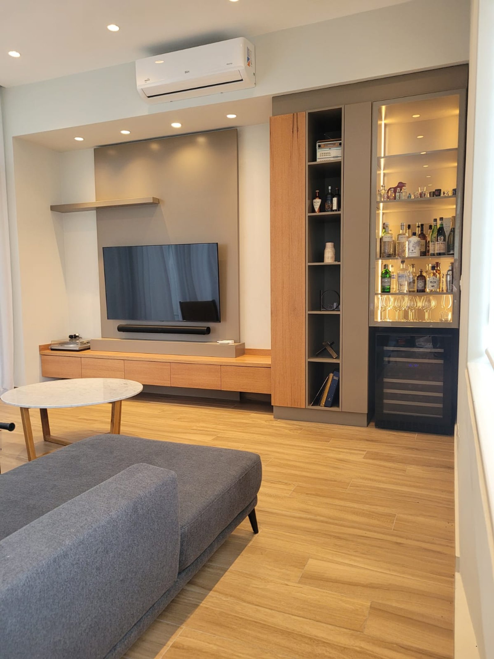 Living moderno con sofá en L gris, mueble integrado y barra de bar — proyecto Belgrano, por Licefe Carpentry SRL, en Belgrano